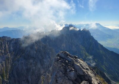 A Rocky Mountain Tops With Clouds