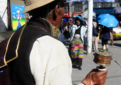 A Man Holding A Prayer Wheel