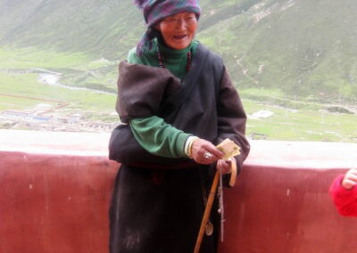 A Woman Standing On A Ledge With A Stick