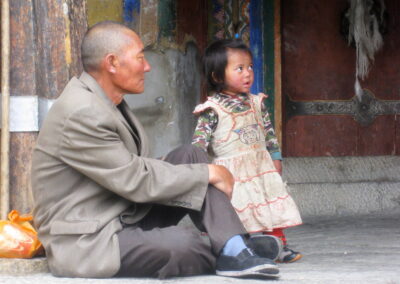 A Man And Child Sitting On The Ground
